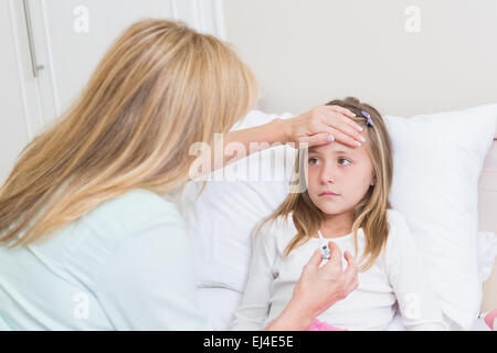 Mother measuring her daughters temperature Stock Photo