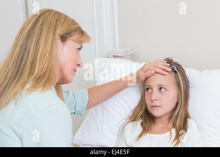 Mother measuring her daughters temperature Stock Photo