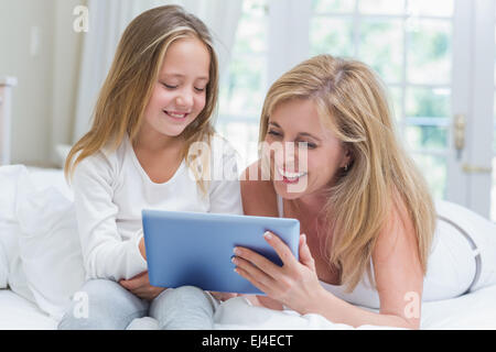 Mother and daughter using tablet pc in the bed Stock Photo