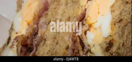 Egg and bacon in brown wholemeal bread sandwich. Stock Photo