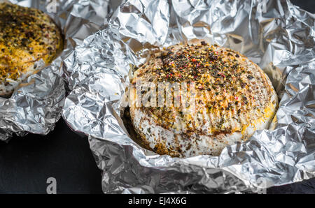 Grilled Camembert Cheese with Spices in Aluminum Foil Stock Photo