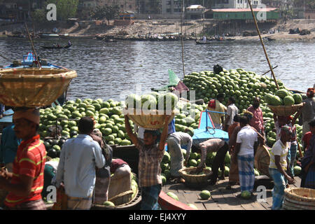 Workers unload watermelons from the boats at Sadarghat for selling in Dhaka, Bangladesh. March 21, 2015 Bumper production of watermelon in Bangladesh this season. Experts have said that the good quality watermelons were a bumper harvest this year owing to favoring weather and improved farming in Bangladesh. Stock Photo