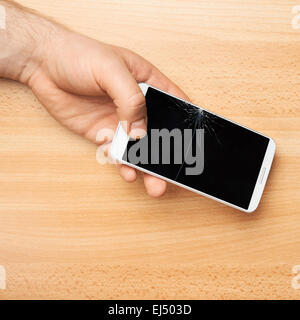 Hands holding a phone with a broken screen Stock Photo