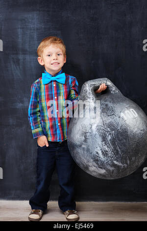 Smiling encoureged redhead school-boy holding huge weight Stock Photo