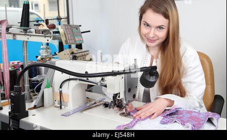 A Seamstress woman sewing in a  tailor's shop Stock Photo