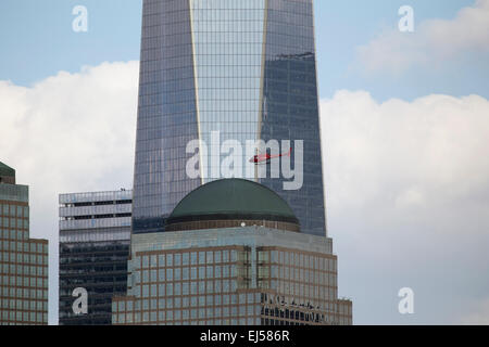 Red Helicopter flies in front of new One World Trade Center (1WTC), Freedom Tower, New York City, New York, USA City, New York, USA Stock Photo