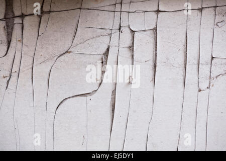 A wall covered in cracked white paint. Stock Photo