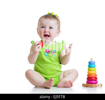 toddler girl playing with colorful toy pyramid Stock Photo