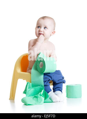 toddler child sitting on chamber pot with toilet paper Stock Photo