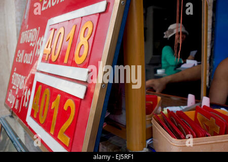 Foreign exchange rates are posted on a sign at a money exchange shop in Kampong Cham, Cambodia. Stock Photo