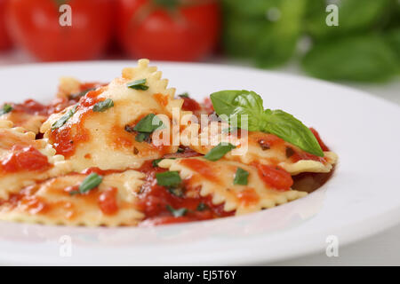 Italian Pasta Ravioli with tomatoes and basil meal on a plate Stock Photo