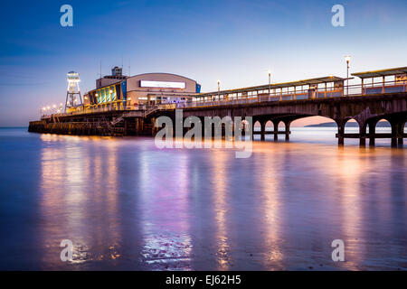 The lights of Bournemouth Pier at night reflected in the wet sand on the beach. Dorset  England UK Europe. Stock Photo