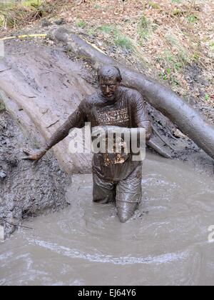 Craufurdland Estate, Ayrshire, Scotland, UK. 22nd March, 2015. Muddy Trial. A man enters a muddy ditch in the Craufurdland Estate. Competitors take part in the 5 and 10k cross country muddy trial fun runs. Stock Photo