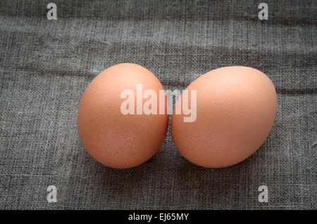 Two chicken eggs on hessian linen fabric cloth texture Stock Photo