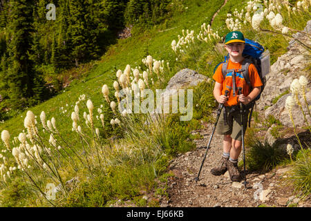 A young backpacker enjoys fields of bear grass along the Kautz Creek trail in Mount Rainier National Park, Washington, USA. Stock Photo