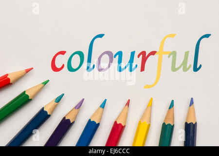 Abstract composition of a set wooden colour pencils against a white background with the text colourful Stock Photo