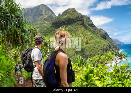 Hikers on the Kalalau Trail near Hanakapiai Beach see the Na Pali Coast on Kauai Stock Photo