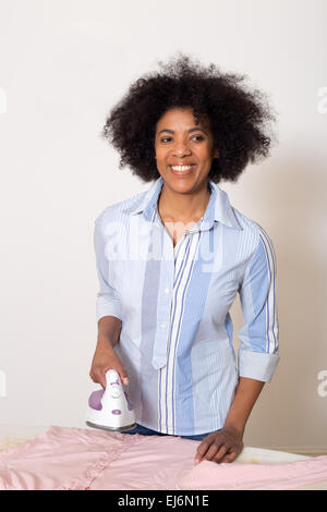 young woman ironing her clothes at home Stock Photo