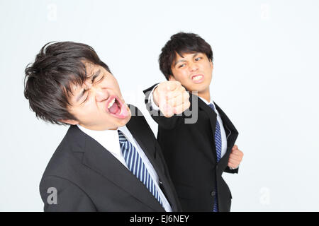 Young Japanese businessmen fighting Stock Photo