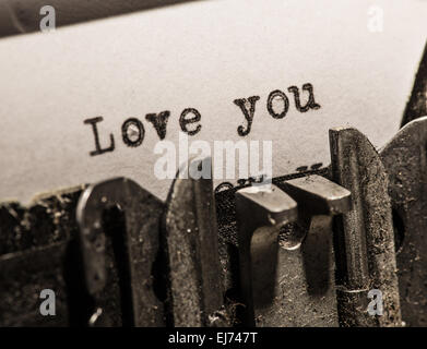 Typewriter with white paper page on wooden table. sample text Love you. Stock Photo