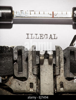 Typewriter with white paper page on wooden table. sample text Illegal. Stock Photo