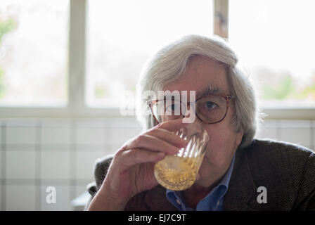 70s elderly man drinking orange juice Stock Photo