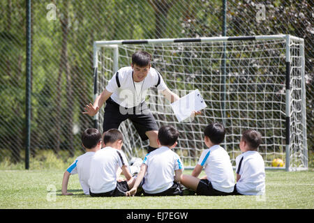 Coach for the boys on the football field interpretation skills Stock Photo