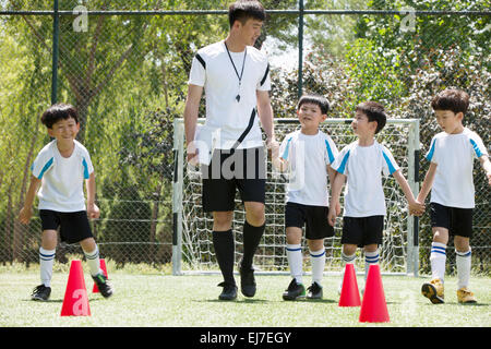 The football coach and the boys on the football field Stock Photo