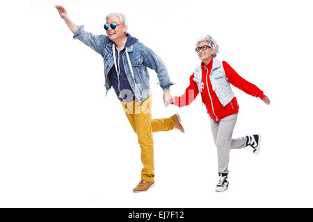 Elderly couple run hand in hand Stock Photo