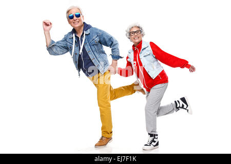 Elderly couple run hand in hand Stock Photo