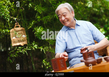 The old man sat in the yard to play chess Stock Photo