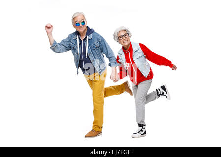 Elderly couple run hand in hand Stock Photo