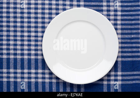 White classic plate on blue checkered tablecloth. Stock Photo