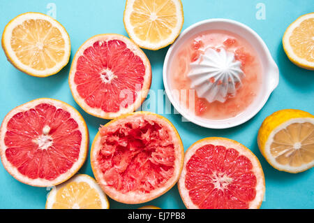 Lemons and grapefruits on the light blue background with a squuzer Stock Photo