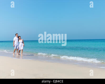 Young happy couple walking on the beach Stock Photo