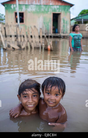 2015 flooding in Brazilian Amazon - children play in the dirty waters of Acre river at Taquari district, Rio Branco city, Acre State. Floods have been affecting thousands of people in the state of Acre, northern Brazil, since 23 February 2015, when some of the state’s rivers, in particular the Acre river, overflowed. Further heavy rainfall has forced river levels higher still, and on 03 March 2015 Brazil’s federal government declared a state of emergency in Acre State, where current flood situation has been described as the worst in 132 years. Stock Photo