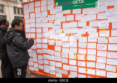 New Yorkers and visitors celebrate the United Nations International Day of Happiness by writing how they will share their happiness in Madison Square in New York on Friday, March 20, 2015. The festive day, which shares the date with the first day of Spring, was celebrated by Mother Nature with a snowstorm predicted to drop several inches of snow on an unhappy populace tired of the snow and winter. (© Richard B. Levine) Stock Photo