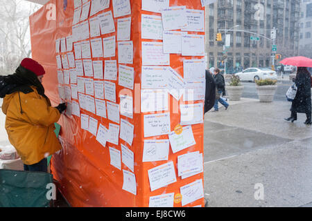 New Yorkers and visitors celebrate the United Nations International Day of Happiness by writing how they will share their happiness in Madison Square in New York on Friday, March 20, 2015. The festive day, which shares the date with the first day of Spring, was celebrated by Mother Nature with a snowstorm predicted to drop several inches of snow on an unhappy populace tired of the snow and winter. (© Richard B. Levine) Stock Photo
