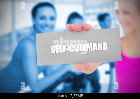 Fit blonde holding card saying self command Stock Photo