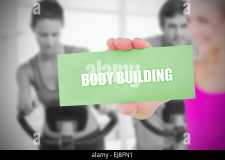 Fit blonde holding card saying body building Stock Photo