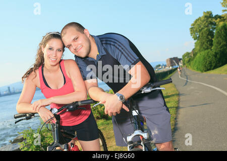 Portrait of a happy young couple on mountain bikes Stock Photo