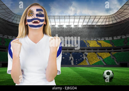 Excited fan in uruguay face paint cheering Stock Photo