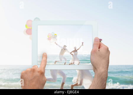 Composite image of hand holding tablet pc Stock Photo