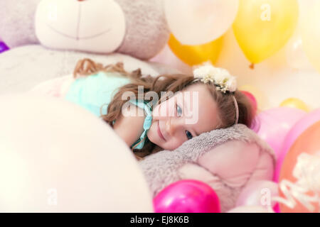 Adorable little girl lying on plush bear Stock Photo