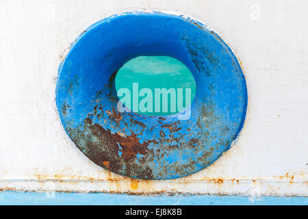 Empty blue hawse in old white rusted ship hull Stock Photo