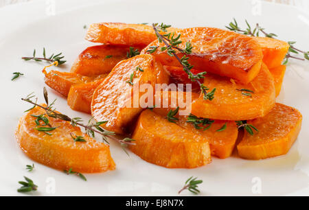 Baked sweet potato wedges on  white plate. Selective focus Stock Photo