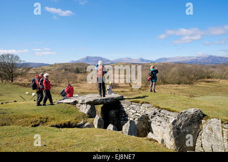 Ramblers group at Capel Garmon Neolithic burial chamber with Snowdonia mountains in distance. Capel Garmon, Conwy, Wales, UK Stock Photo