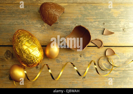 Chocolate easter eggs with decoration ribbon over a wooden backdrop Stock Photo