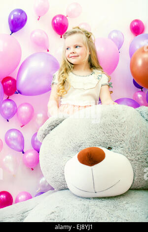 Smiling little girl posing with plush bear Stock Photo