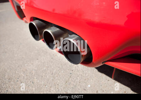 Sports car exhaust pipe with three chromed tubes Stock Photo